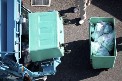 Waste collection vehicle with safety signage parked at a business premises